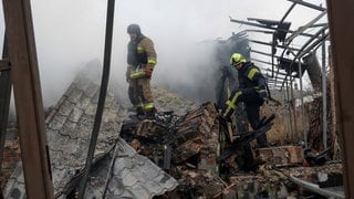 Rettungskräfte begutachten die Einschlagsstelle einer Drohne in Charkiw