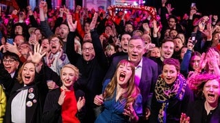 Heidi Reichinnek (3. von links) und Jan van Aken (4. von links) freuen sich bei der Party der Linken über das Wahlergebnis.