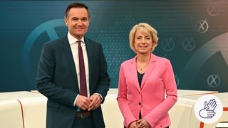 Sascha Becker und Birgitta Weber stehen in einem Studio. Dazu rechts unten im Bild : Das SWR-Zeichen für Deutsche Gebärdensprache. Es ist ein weißer Kreis. Darin ist eine blaue Zeichnung: Es sind zwei Hände. Die Hände gebärden.  