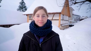 Stefanie setzt sich im Verein taxmenow für Steuergerechtigkeit ein. Stefanie steht vor einem Haus in einer Winterlandschaft. Sie schaut mit direktem Blick in die Kamera.