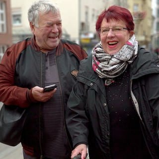 Jutta und Kurt lachen gemeinsam in Karlsruhe. Er lacht seine Jugendliebe an.