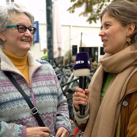  Rentnerin spricht mit Reporterin Tici von SWR Heimat in der Karlsruher Innenstadt.