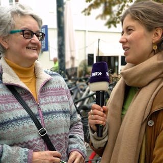  Rentnerin spricht mit Reporterin Tici von SWR Heimat in der Karlsruher Innenstadt.