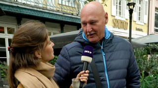 Werner spricht bei der Straßenumfrage in der Karlsruher Innenstadt mit Tici über seine Gefühle und wann er zuletzt geweint hat. Werner hat eine Glatze, ist groß und schaut zu Tici, die ein Mikro in der Hand hält. 