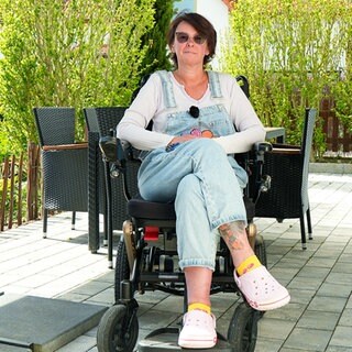 Sonja sitzt in ihrem Rollstuhl auf ihrer Terrasse. Sie hat Multiple Sklerose und erzählt davon.