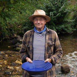 Michael steht in einem Flussbett und lächelt in die Kamera. Er wäscht Gold und erzählt von seiner Leidenschaft.