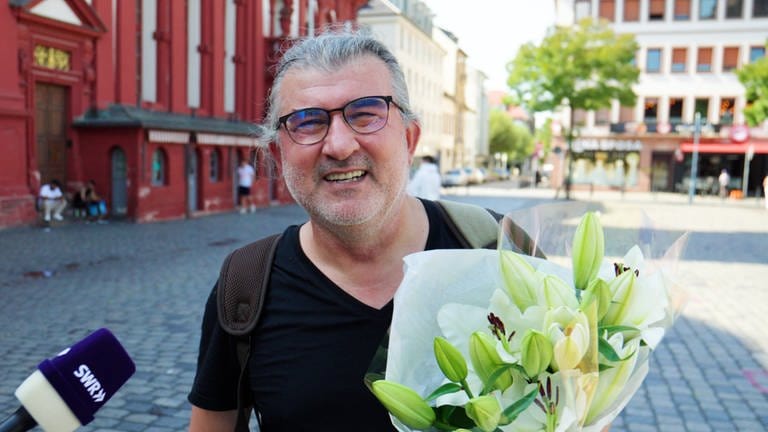 Ein Mann mit weißen Haaren und Brille lächelt in die Kamera.