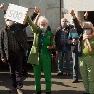 Eine Gruppe von Menschen zeigt die Daumen nach oben