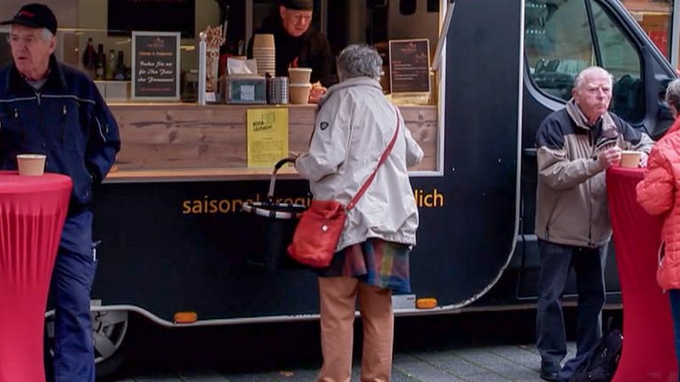 Frau kauft Suppe am Food-Truck