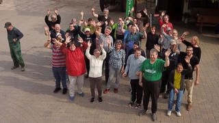 Gruppe von Menschen winkend von oben fotografiert