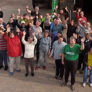 Gruppe von Menschen winkend von oben fotografiert