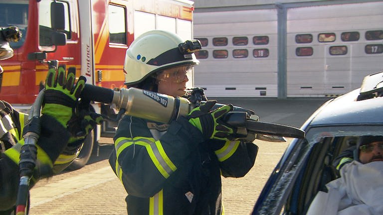 Feuerwehrfrau Selina beim Aufschneiden eines Autos 