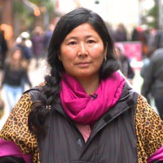 Junge asiatische Frau in Fußgängerzone