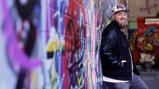 René aus Kaiserslautern steht vor Graffiti Wand