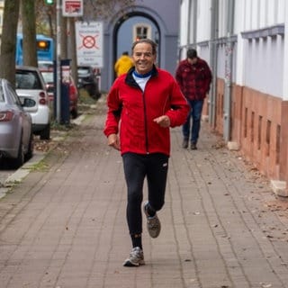 Älterer Herr joggend auf Gehweg