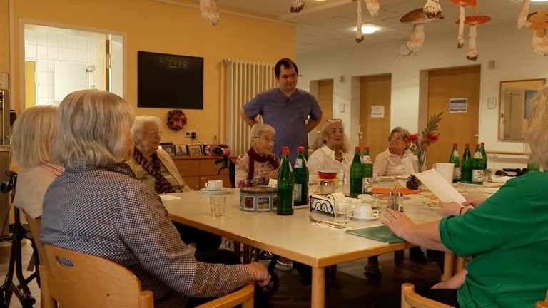 Junger Mann im Altenheim in Pflegerkleidung.