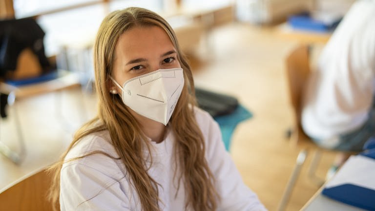 Eine junge Frau mit langen, mittelblonden Haaren im Outfit der Malteser