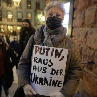 Frau mit Plakat gegen Putin