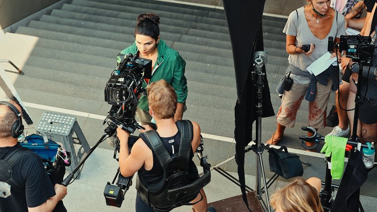 Ein Kamerateam hat auf einem Treppenaufgang ein Filmset eingerichtet. 