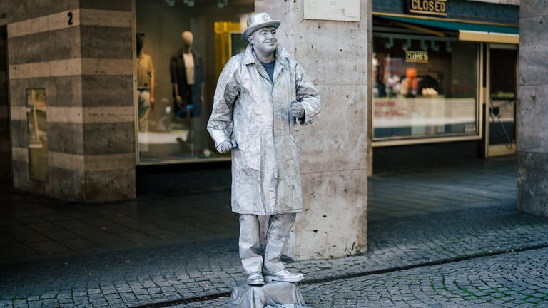 Straßenkünstler Paul versucht, sich als menschliche Statue Geld dazu zu verdienen.