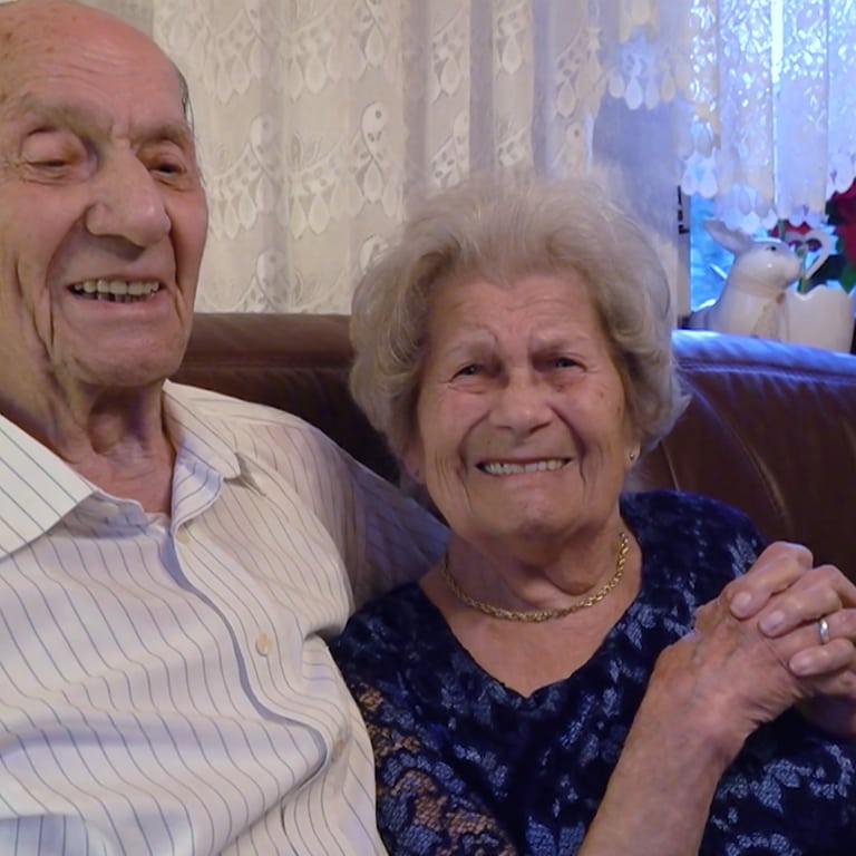 Ein Liebespasst sitzt auf dem Sofa. Sie feiern gemeinsam 75 Jahre Ehe.