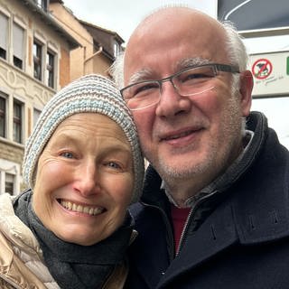 Wir treffen zufällig in Stuttgart-Ost auf Genia und Michael. Das Ehepaar liegt sich im Arm und lächelt in die Kamera.