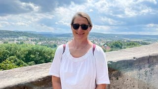 Wir treffen Caroline zufällig in Tübingen. Sie arbeitet im Pflegebereich. Sie steht am Schloss Hohentübingen und lächelt in die Kamera.