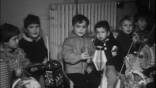 Die 1960er Jahre: Kinder sitzen mit ihren Laternen auf einer Bank