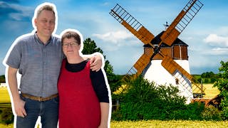 Anke und Andreas stehen Arm in Arm vor ihrer holländischen Turmwindmühle.