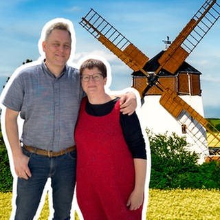 Anke und Andreas stehen Arm in Arm vor ihrer holländischen Turmwindmühle.