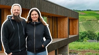 Familie baut Holzhaus in der Natur umgeben von Weinbergen