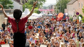 Blick von der Bühne auf eine gut gefüllte Festivalmeile beim SWR Sommerfestival mit vielen Menschen