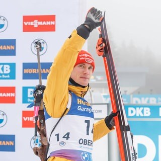 Benedikt Doll bei der Blumenzeremonie nach seinem ersten Platz im Biathlon-Sprint in Oberhof (Deutschland).