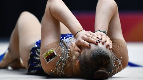 Margarita Kolosov Gymnastin lieg auf dem Boden mit Händen auf dem Kopf, nach Abschluss der letzten Übung