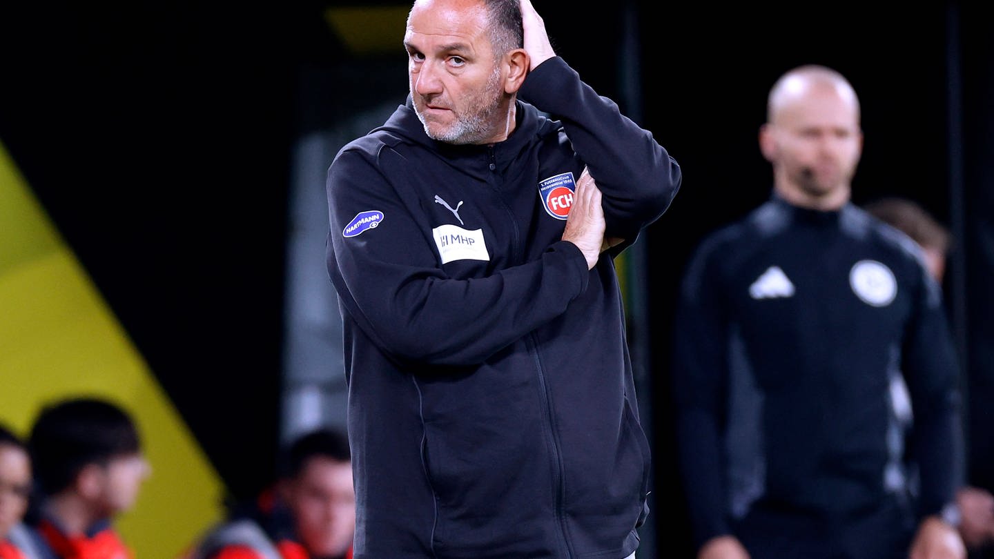 Heidenheim-Trainer Frank Schmidt kratzt sich am Kopf.