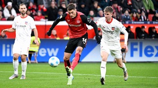 Jan Schöppner vom 1. FC Heidenheim kann Bayer-Stürmer Patrick Schick nicht am Torschuss hindern.