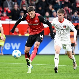 Jan Schöppner vom 1. FC Heidenheim kann Bayer-Stürmer Patrick Schick nicht am Torschuss hindern.