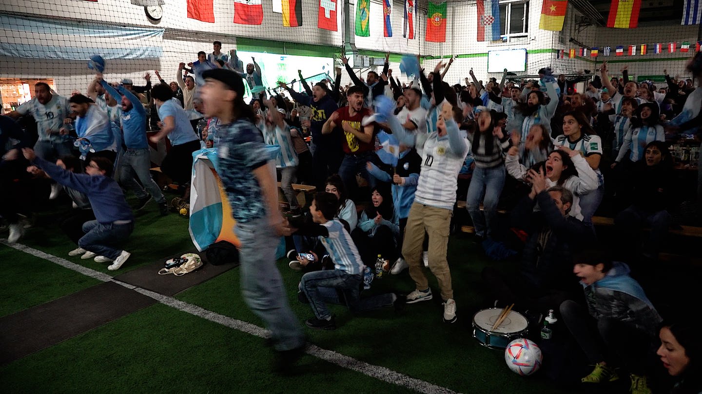 Argentinische Fans bejubeln einen Treffer bei einem Public Viewing in einer Fußballhalle