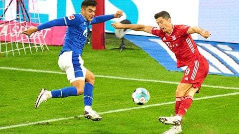 Beim Eröffnungsspiel der Bundesligasaison 202021 verlieren Ozan Kabak (links) und seine Schalker Teamkollegen 0:8 bei den Bayern. Sinnbildlich für die Blamage der Königsblauen: Robert Lewandowskis (rechts) Rabona-Vorlage zum 0:6. 