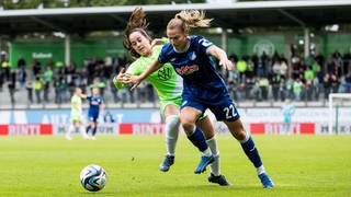 Hoffenheim-Verteidigerin Sarai Linder (rechts in Blau) knöpft Wolfsburgs Nuria Rabano (links in Grün) den Ball ab.