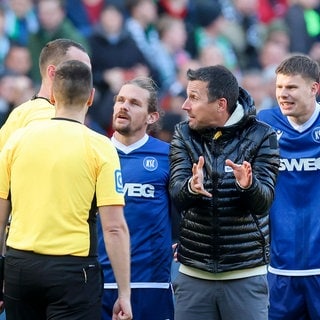 Trainer Christian Eichner (Karlsruher SC) diskutiert nach dem Schlusspfiff mit Schiedsrichter Richard Hempel über die Elfmeterentscheidung