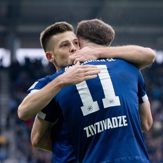 Marvin Wanitzek und Budu Zivzivadze feiern den 1:0-Sieg des Karlsruher SC gegen Preußen Münster.