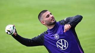 Deniz Undav wirft im DFB-Trainingslager einen Ball