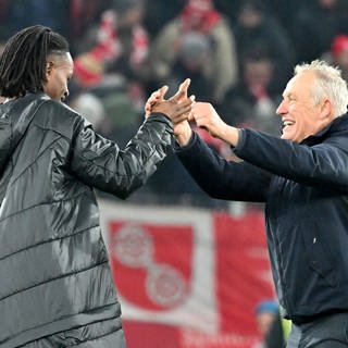 Jordy Makengo und Trainer Christian Streich feiern den Sieg ihres SC Freiburg beim 1. FC Köln.
