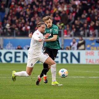 SC-Freiburg-Stürmer Lucas Höler im Duell mit Stuttgarts Verteidiger Anthony Rouault.
