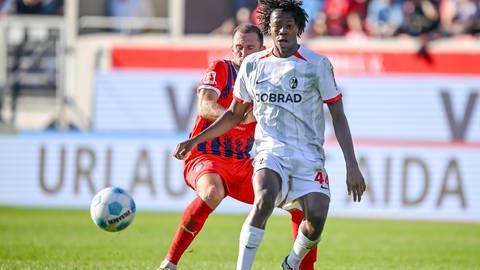 Jonas Föhrenbach (1.FC Heidenheim) und Johan Manzambi (SC Freiburg) im Zweikampf waehrend des Spiels zwischen dem 1. FC Heidenheim 1846 und SC Freiburg.