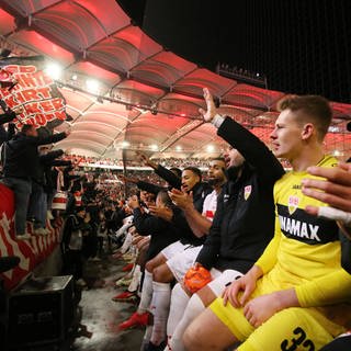 Die Spieler des  VfB feiern in der Cannstatter Kurve mit den Fans nach dem Sieg gegen Augsburg