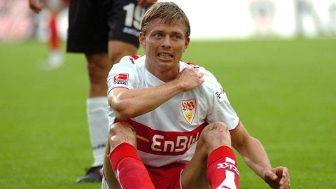 Jon Dahl Tomasson sitzt im VfB-Trikot auf dem Rasen