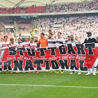 Spieler des VfB Stuttgart halten ein Plakat mit der Aufschrift "Stuttgart International" hoch