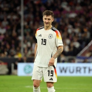 Angelo Stiller lächelnd auf dem Platz bei der Partie Deutschland gegen die Niederlande